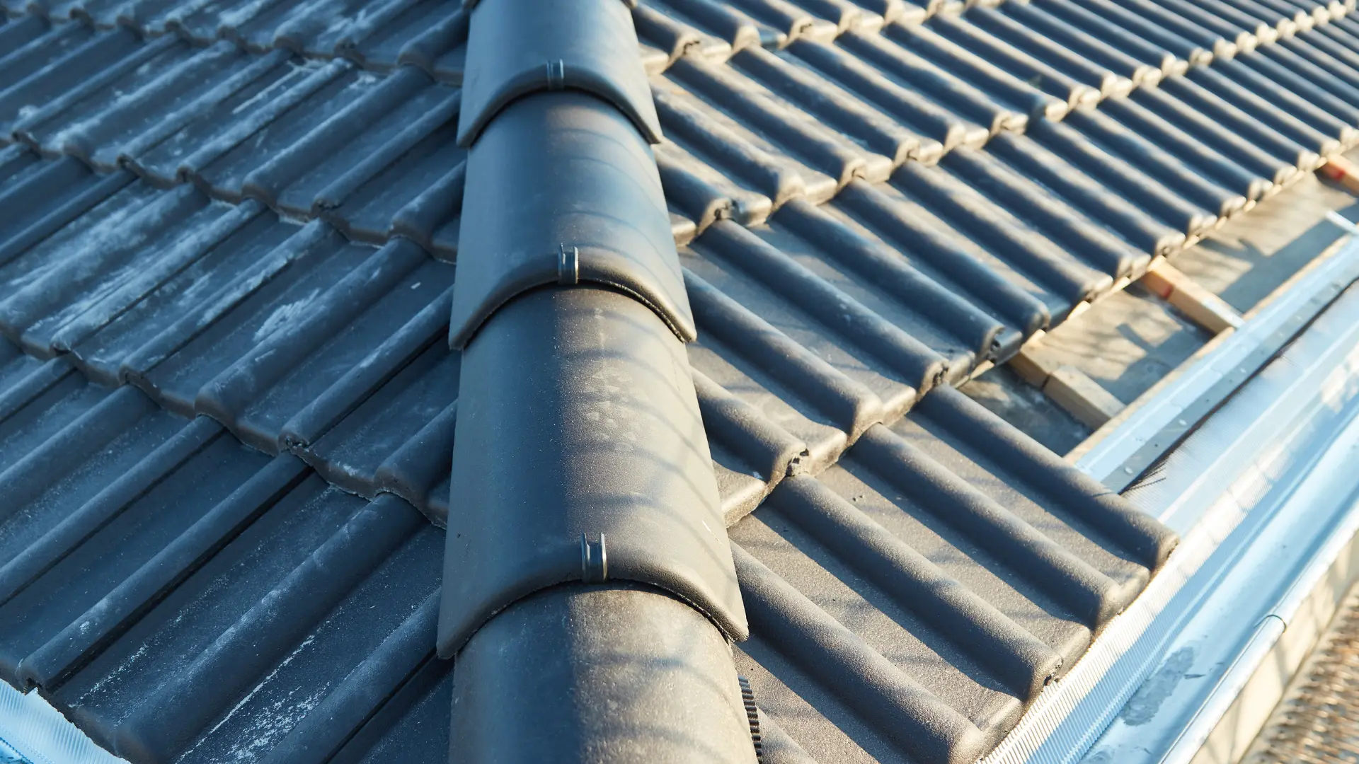 Ridge tiles bedded and pointed in fresh mortar along the apex of a tiled roof